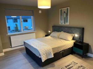 a bedroom with a large bed and a window at 3 bed rooms Vip family house in Dublin