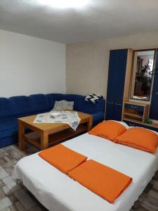 a bedroom with a bed and a blue couch at Home of nature - kuća prirode in Odžak