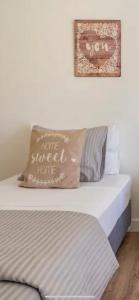 a bed with a pillow that says how the sweet home at Modern Twin Room with a balcony in Montijo