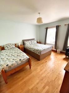 - une chambre avec 2 lits et du parquet dans l'établissement Quiet Farm Bungalow Enniskillen Fermanagh, à Enniskillen