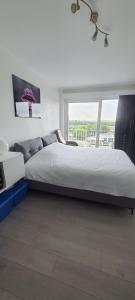 een slaapkamer met een groot bed en een groot raam bij Studio Julian in Middelkerke