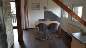 een eetkamer met een tafel en vier stoelen bij Haus Weinheck in Lebach