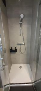 een badkamer met een douche met een glazen deur bij Studio Julian in Middelkerke +39 foto's