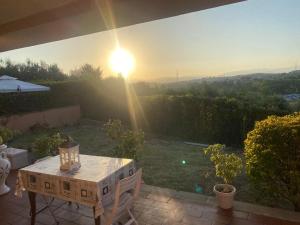 un tavolo su un patio con il tramonto sullo sfondo di Villa Luxury con Vista Golf Club - Rider Cup a Marco Simone