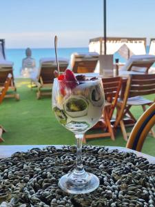 ein Weinglas mit Obst auf einem Tisch. in der Unterkunft Bora Bora Beach Club & Hotel in Isla Grande