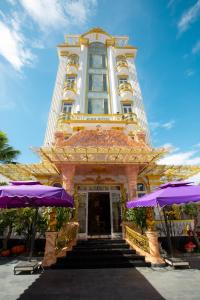 KING VILLA QUẢNG NGÃI في كوانج نجاي: مبنى أمامه مظلات أرجوانية