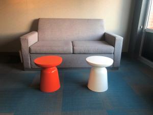 a living room with two tables and a couch at Aloft Raleigh in Raleigh