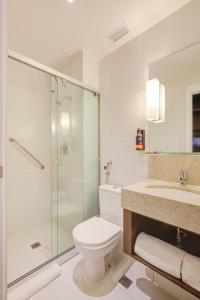 a bathroom with a toilet and a glass shower at Comfort Hotel São Caetano in São Caetano do Sul