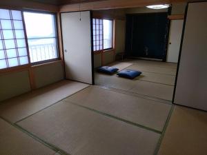 Setouchi base - Vacation STAY 47136v في Mitoyo: غرفة فارغة مع اثنين من الوسائد الزرقاء على الأرض