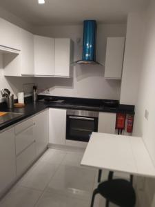 a kitchen with white cabinets and a table in it at Spacious Two bedroom City apartment Longs Place, Dublin 8 in Dublin