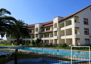 un edificio con piscina frente a un edificio en Hotel Palmas de La Serena, en La Serena