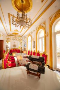 KING VILLA QUẢNG NGÃI في كوانج نجاي: غرفة معيشة مع طاولة وكراسي وثريا