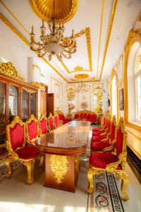 Cette chambre comprend une table, des chaises et un lustre. dans l'établissement KING VILLA QUẢNG NGÃI, à Quảng Ngãi