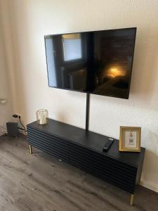 a living room with a large tv on the wall at Moderne Ferienwohnung 5min vom Wasserschloss - Free WIFI & Netflix in Neukirchen