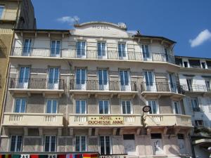 Un edificio alto con un cartel. en Hôtel Duchesse Anne, en Lourdes