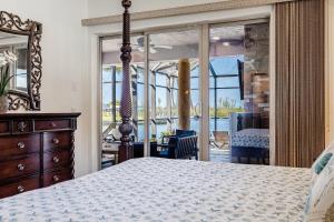 1 dormitorio con 1 cama con tocador y ventana en Heated Pool and Spa, Sleeps 16! - Villa Mangrove, en Cabo Coral