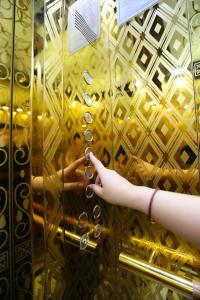 une personne arrive dans un ascenseur en or dans l'établissement KING VILLA QUẢNG NGÃI, à Quảng Ngãi