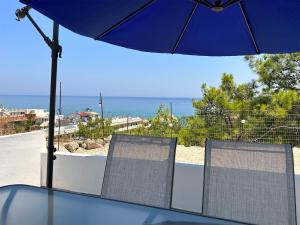 two chairs sitting on a table under an umbrella at Paradis Studios in Archangelos