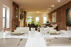 Unique 1BR Greenwich Penthouse Escape! في نيويورك: غرفة طعام مع طاولة بيضاء مع فضيات