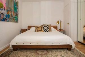 a bedroom with a bed with white sheets and a rug at Unique 1BR Greenwich Penthouse Escape! in New York
