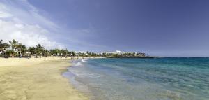 a beach with a group of people on the water at Barceló Teguise Beach - Adults Only in Costa Teguise