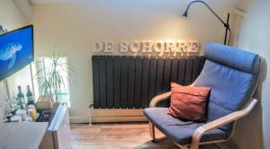 - Silla azul con almohada en la sala de estar en B&B De Schorre, en Boom