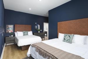 a bedroom with two beds and a blue wall at Tranquil Haven Close to Broadway with Free Parking in Nashville