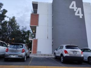 グアダラハラにあるDepartamento cerca de zoológico y estadio Jaliscoの建物前に停車する車両群