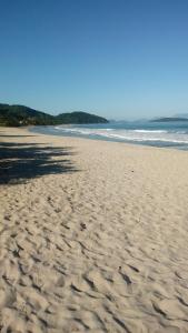 a sandy beach with footprints in the sand at Pousada Simone Paulista in Paraty
