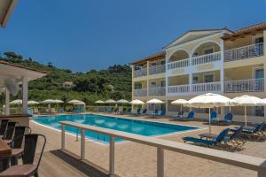 a hotel with a swimming pool and chairs and umbrellas at Manousis ApartHotel in Tsilivi