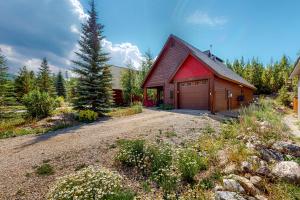a house with a red roof and a garage at Cozy Cabin Retreat in Grand Lake
