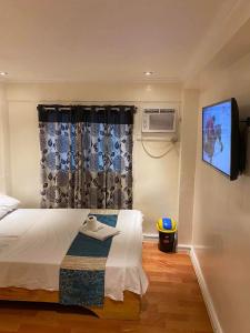 a bedroom with a bed with a tv and a window at RJ Travellers Inn in Catbalogan