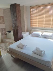 1 dormitorio con 1 cama blanca grande y toallas. en Дунав билдингс 3, en Pleven
