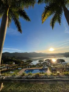 a view of a body of water with palm trees at Pousada Recanto Varanda do Sol in Joanópolis