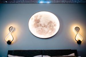a wall with two lights and a moon on it at Relaxveld Galaxy in Curtea de Argeş