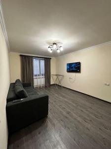 een woonkamer met een zwarte bank in een kamer bij 1Cosy apartment near airport EVN in Jerevan