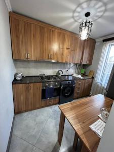 a kitchen with wooden cabinets and a wooden table at 1Cosy apartment near airport EVN in Yerevan