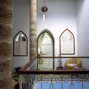 a staircase with two arched windows and a mirror at Dar Lazuli Bed & Breakfast in Essaouira