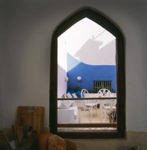 a view of a table and chairs through a window at Dar Lazuli Bed & Breakfast in Essaouira