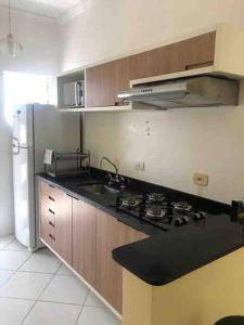 uma cozinha com um fogão, um lavatório e um frigorífico em Apartamento completo Ubatuba - Maranduba em Ubatuba