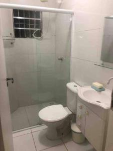 uma casa de banho com um chuveiro, um WC e um lavatório. em Apartamento completo Ubatuba - Maranduba em Ubatuba