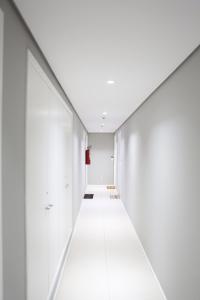 a hallway with white walls and a white floor at Apartamento 1903 no Bosque com quarto cozinha completa e vaga de garagem in Campinas