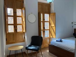 a bedroom with a bed and a chair and a table at Sagunto Castillo 17 in Sagunto