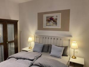 a bedroom with a bed with two lamps and a picture on the wall at Ferienwohnung Casa Conti Goslar in Goslar