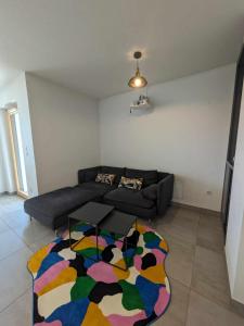 a living room with a couch and a colorful rug at Appartement moderne tout équipé (Vidéoprojecteur, Domotique etc...) in Saint-Louis