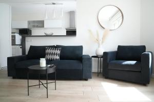 un soggiorno con 2 divani blu e un tavolo di Cosy & Charmant Appartement proche Disney a Ferrières-en-Brie