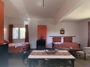 1 dormitorio con 2 camas, mesa y sillas en La Oma en La Cumbre
