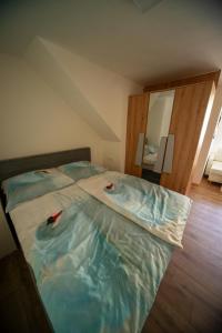 um quarto com uma cama grande e lençóis azuis em Sport apartments em Radovljica