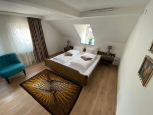 a bedroom with a large bed and a blue chair at Altes Tor in Filsen