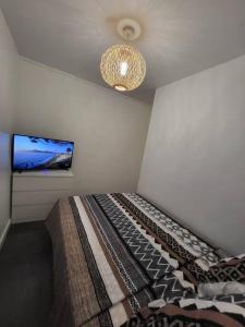 a bedroom with a bed and a flat screen tv at Pépite entre Paris et Versailles in Chaville